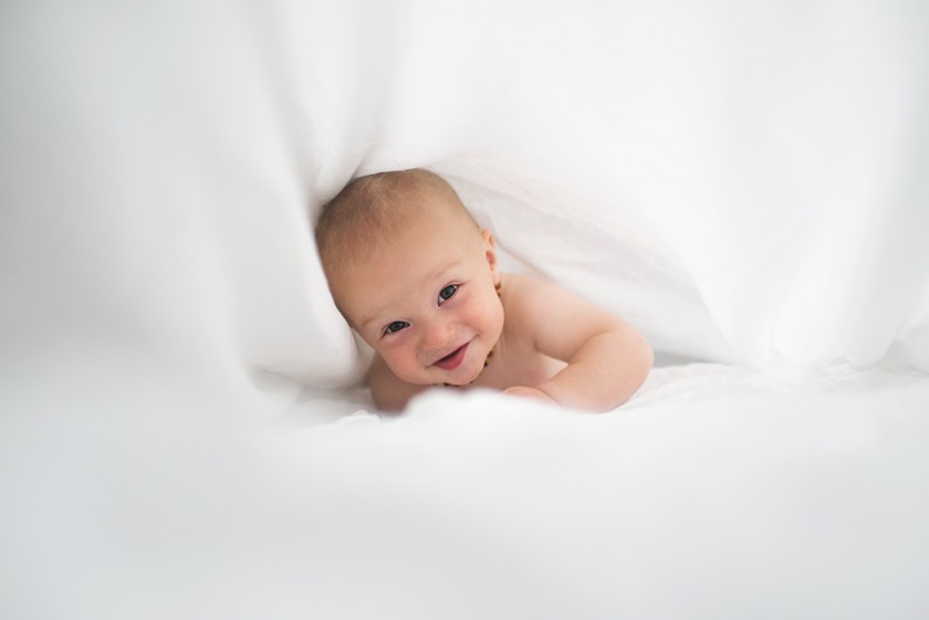 picture of baby laying in the bed sheets by Kellie Bieser