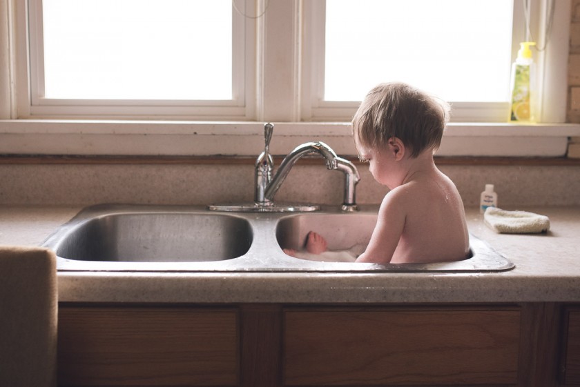 toddler getting a sink bath by Heather Mohr