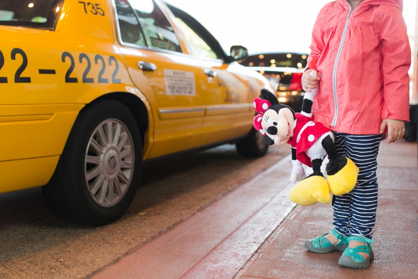 girl standing by a taxi holding Minnie Mosue by Kristy Dooley