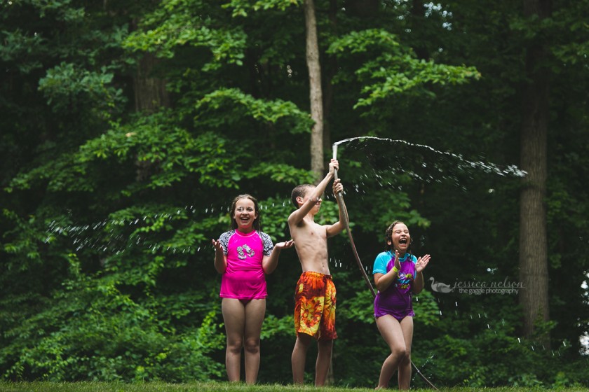 photo of kids playing in the water hose by Jessica Nelson