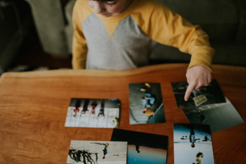 picture of kid looking at printed photos by Cassandra McCasley of Twist and Shutter Photography