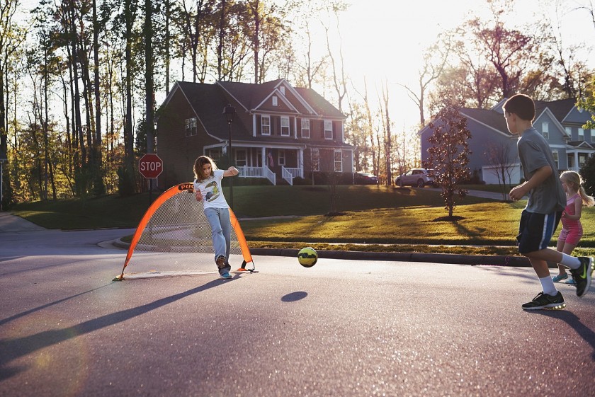 picture of kids playing soccer in the street by Brittany Blake