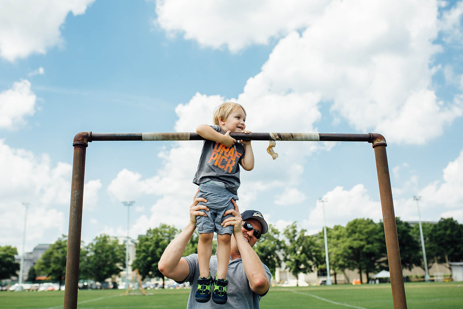 picture of kid hanging on poles on a football field by Michelle Stoddard