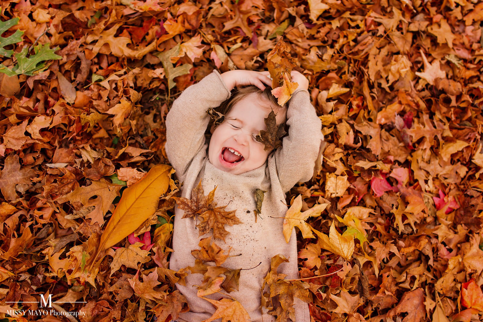 baby in a leaf pile by Missy Mayo