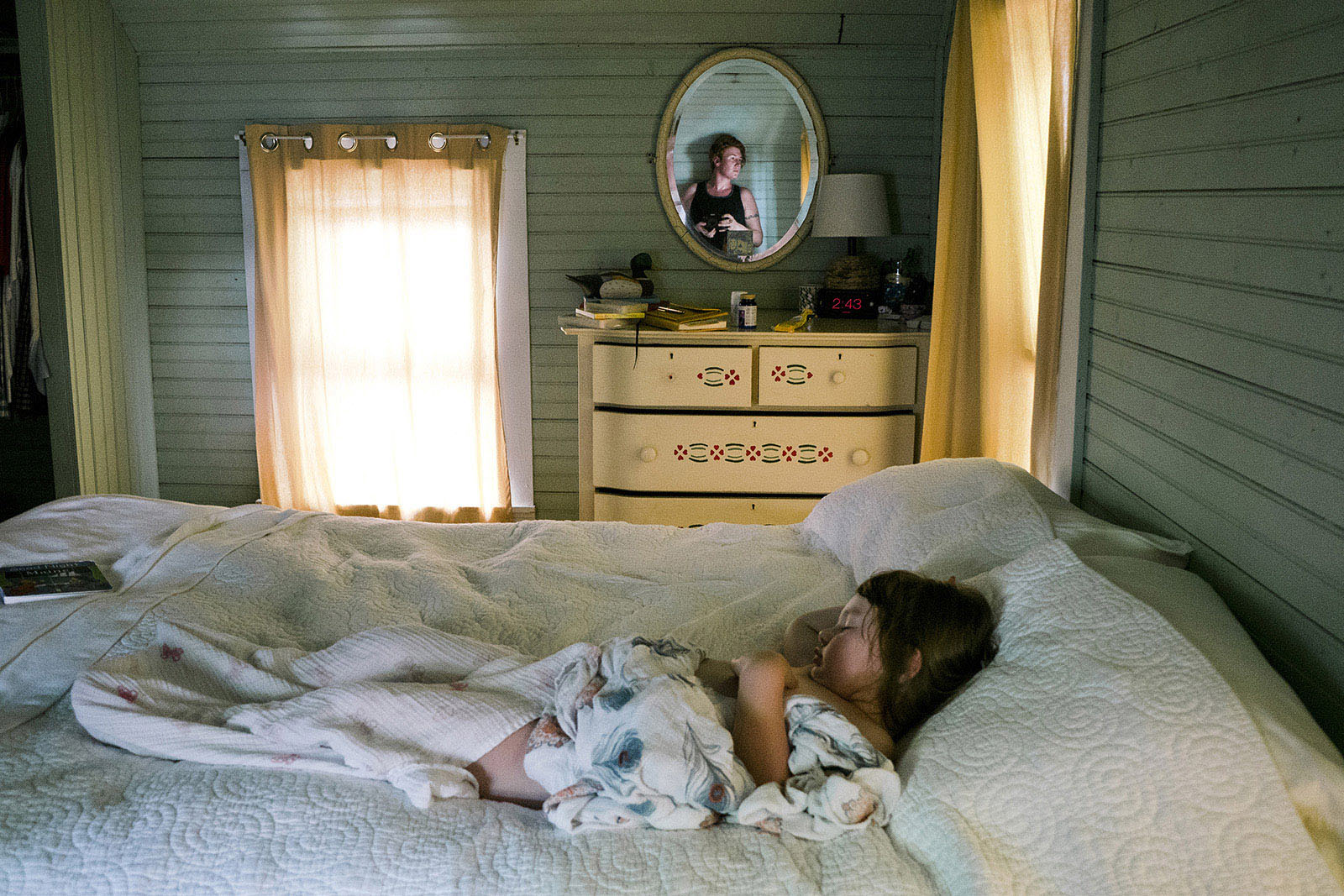 photo of kid sleeping and woman taking a picture by Olivia Gatti