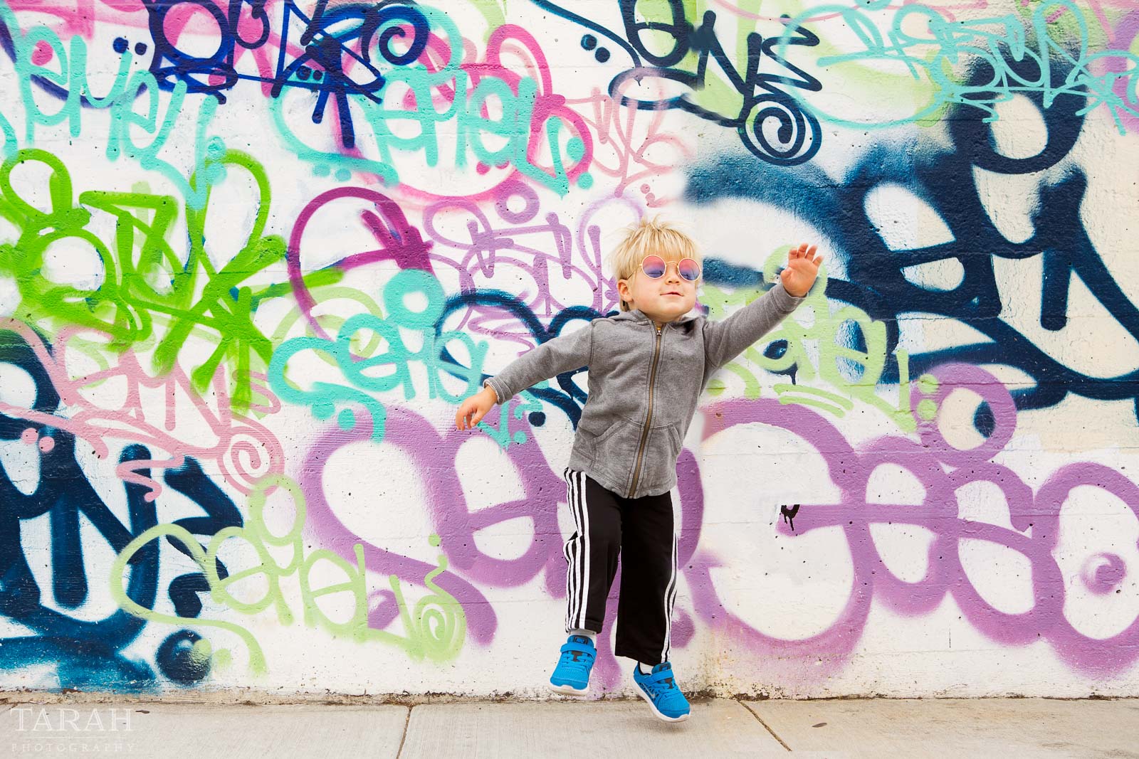 pic of kid by a grafitti wall by Tarah Beaven