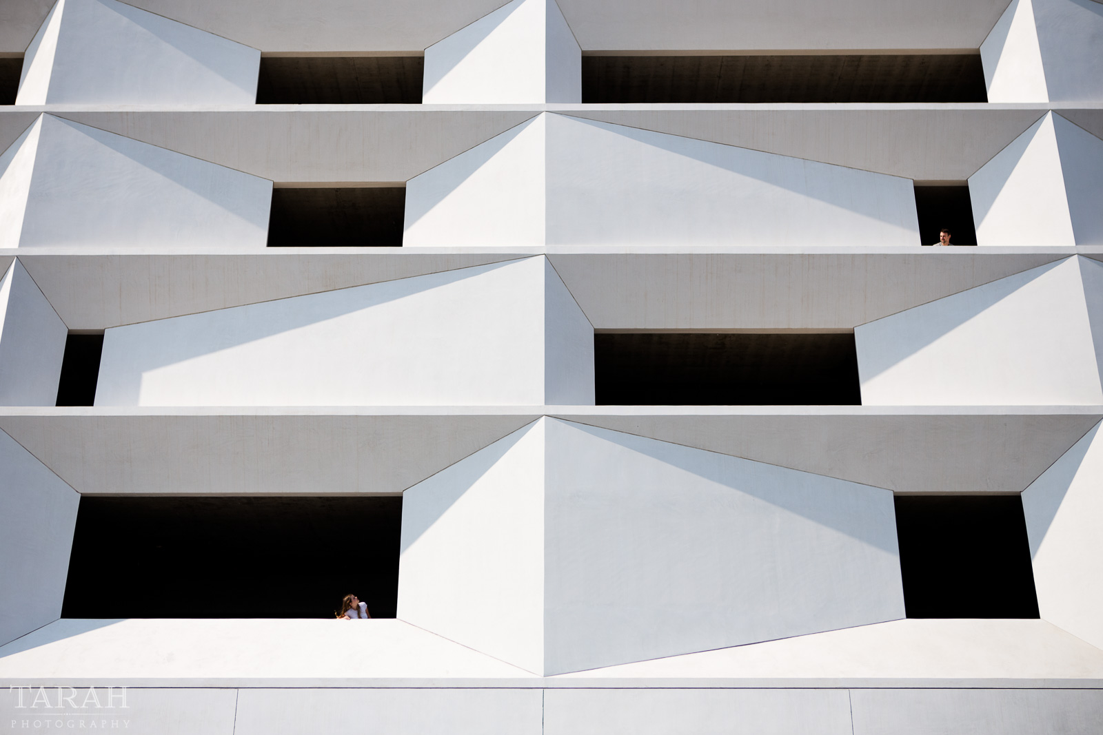 picture of people looking out windows of a parking garage by Tarah Beaven