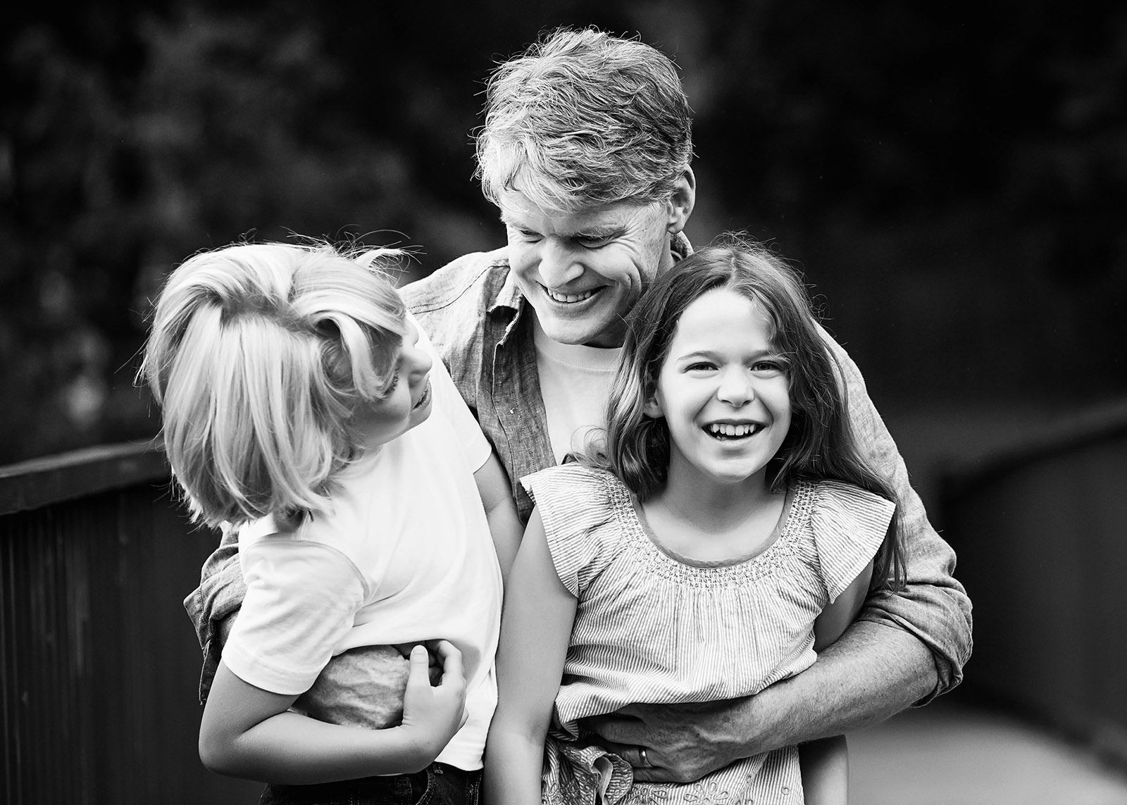 dad holding kids smiling and laughing games for happy family photos by leslie crane